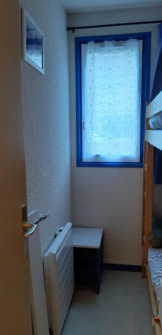 Chambre avec petite fenêtre donnant sur le parking